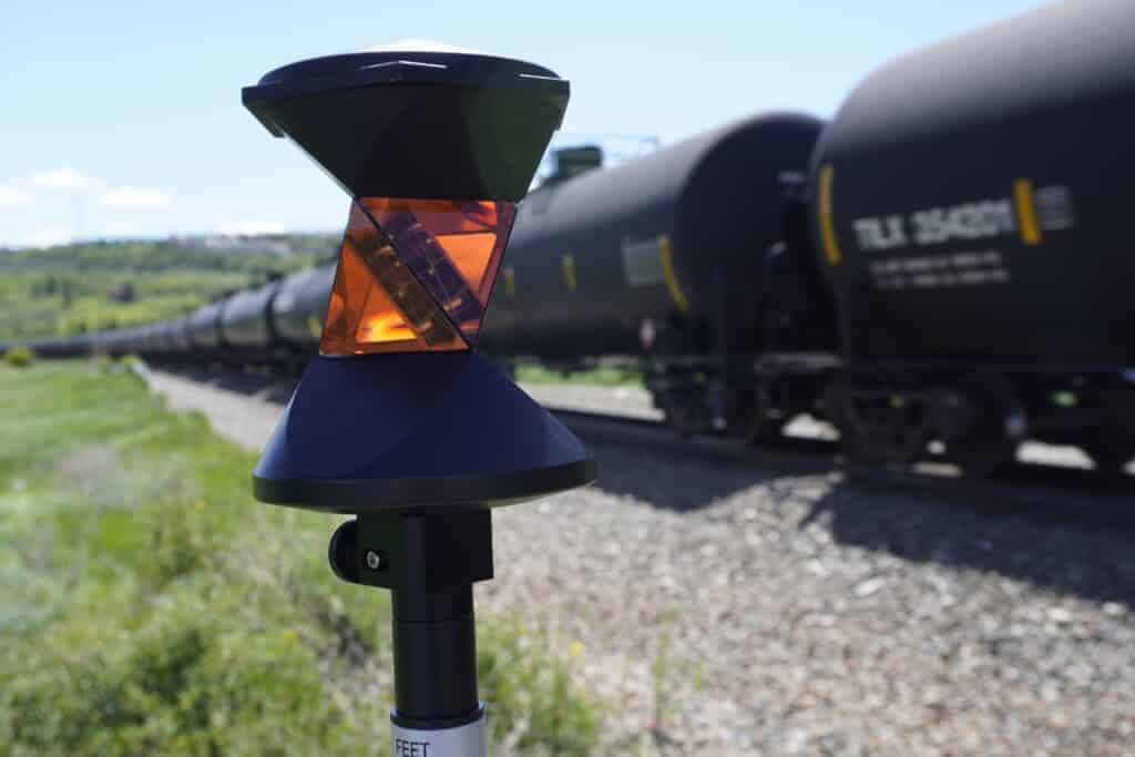 Survey prism on pole used for total station measurements near railway