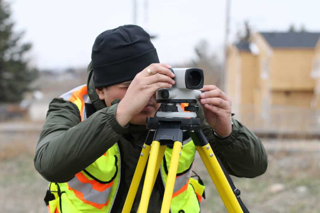 Surveyor using an optical level on a construction site