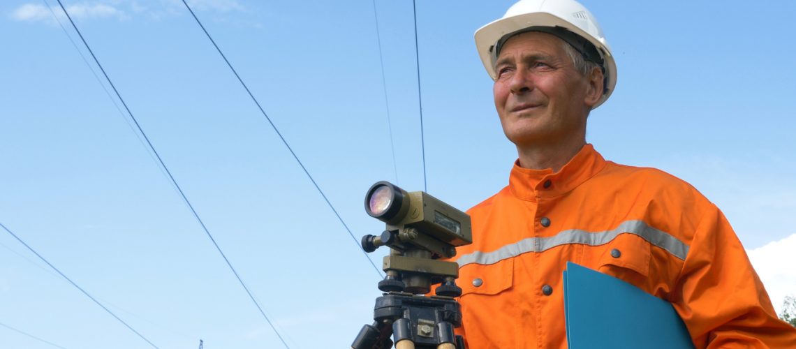 experienced survey specialist stands near dumpy level